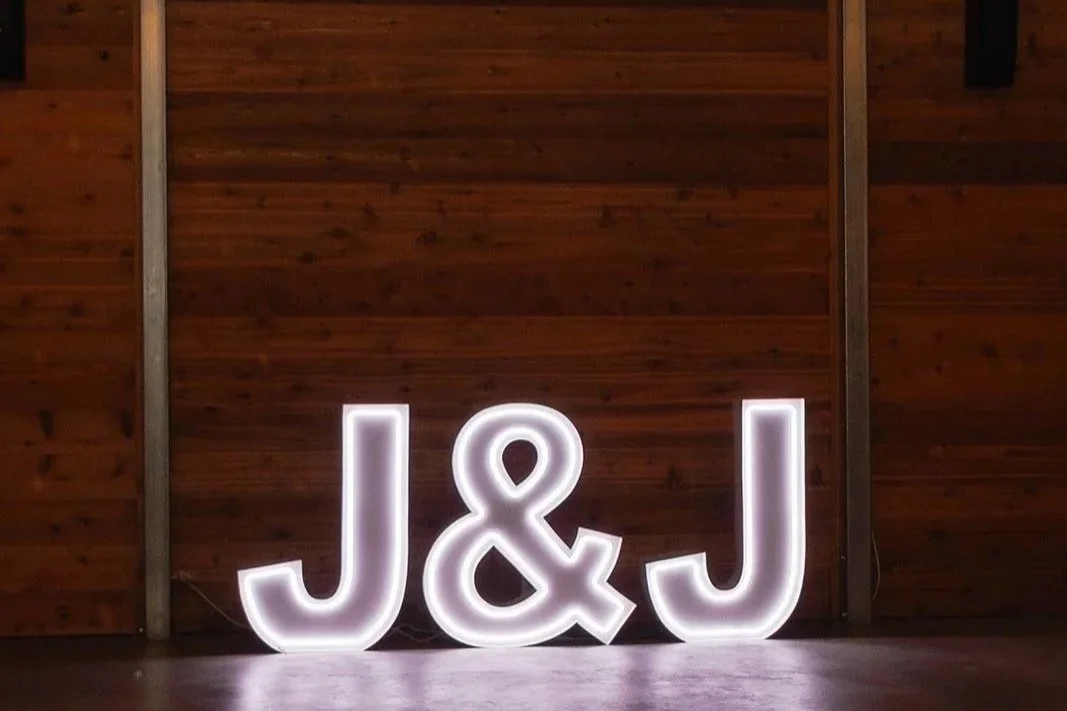 Illuminated J & J letters on wooden wall.