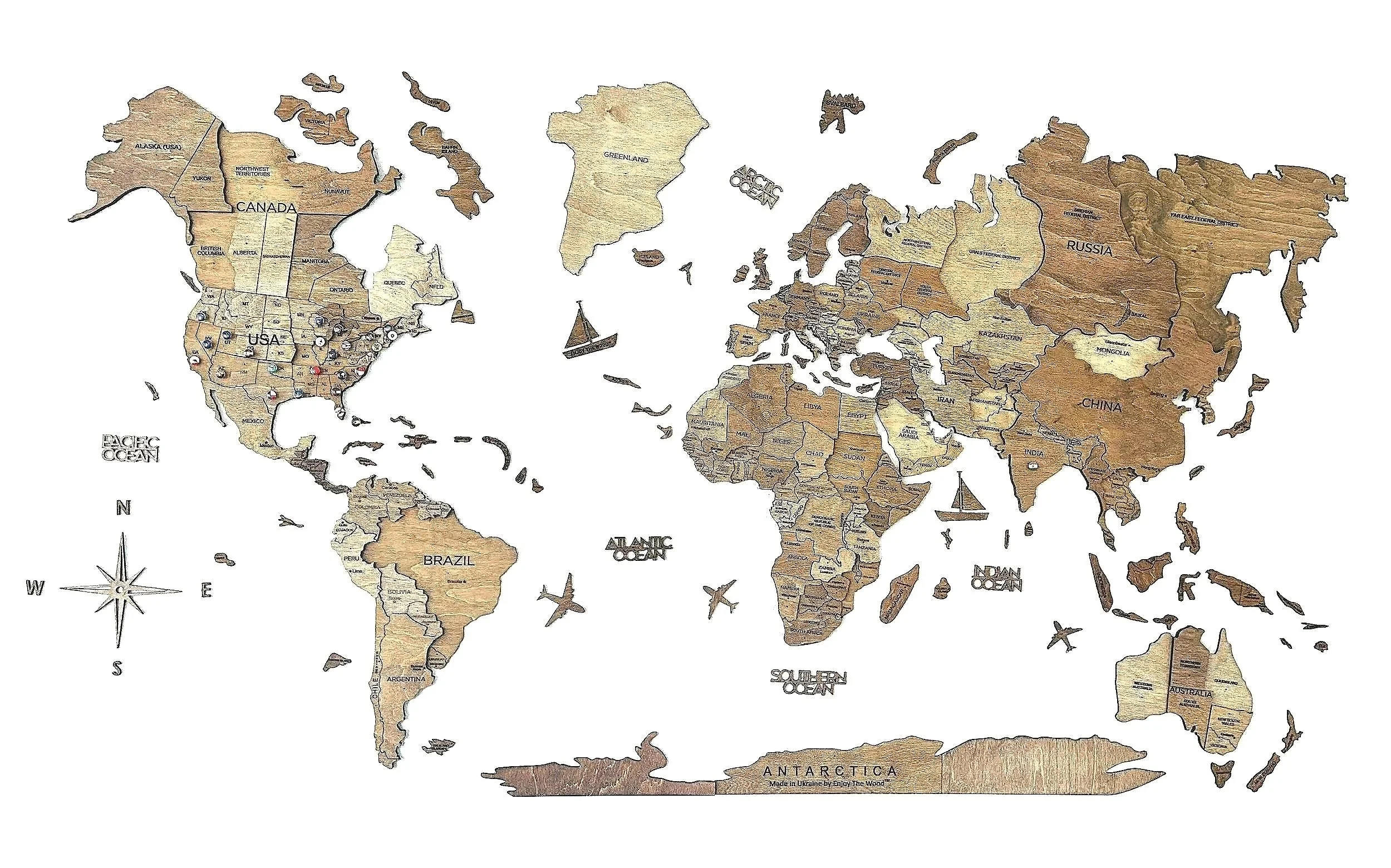 A world map made of wood with country names and borders clearly visible, including US, Canada, Russia, China, Africa, South America, Australia, and Antarctica, with small aircraft illustrations and a compass rose.