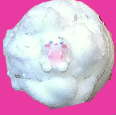 A fluffy white object with a cute pink pig face on it, set against a bright pink background.