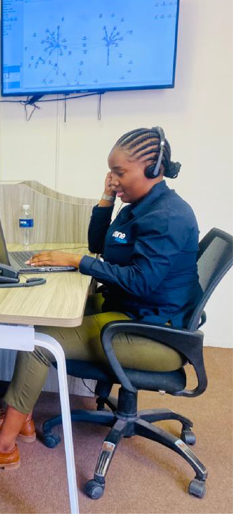 Our tech support wearing a headset, sitting at a desk with a laptop,helping a client