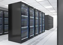 A row of black server racks in a data center with white flooring and ceiling.