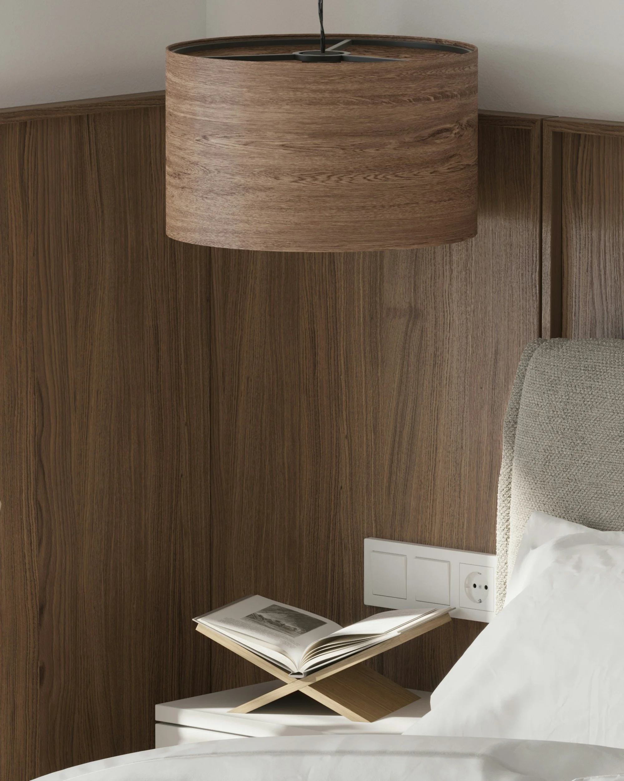 Elegant modern bedroom corner featuring dark wood wall panelling, a sculptural wooden pendant light, soft neutral bedding and a styled bedside shelf with an open book, creating a warm and calming boutique hotel atmosphere.