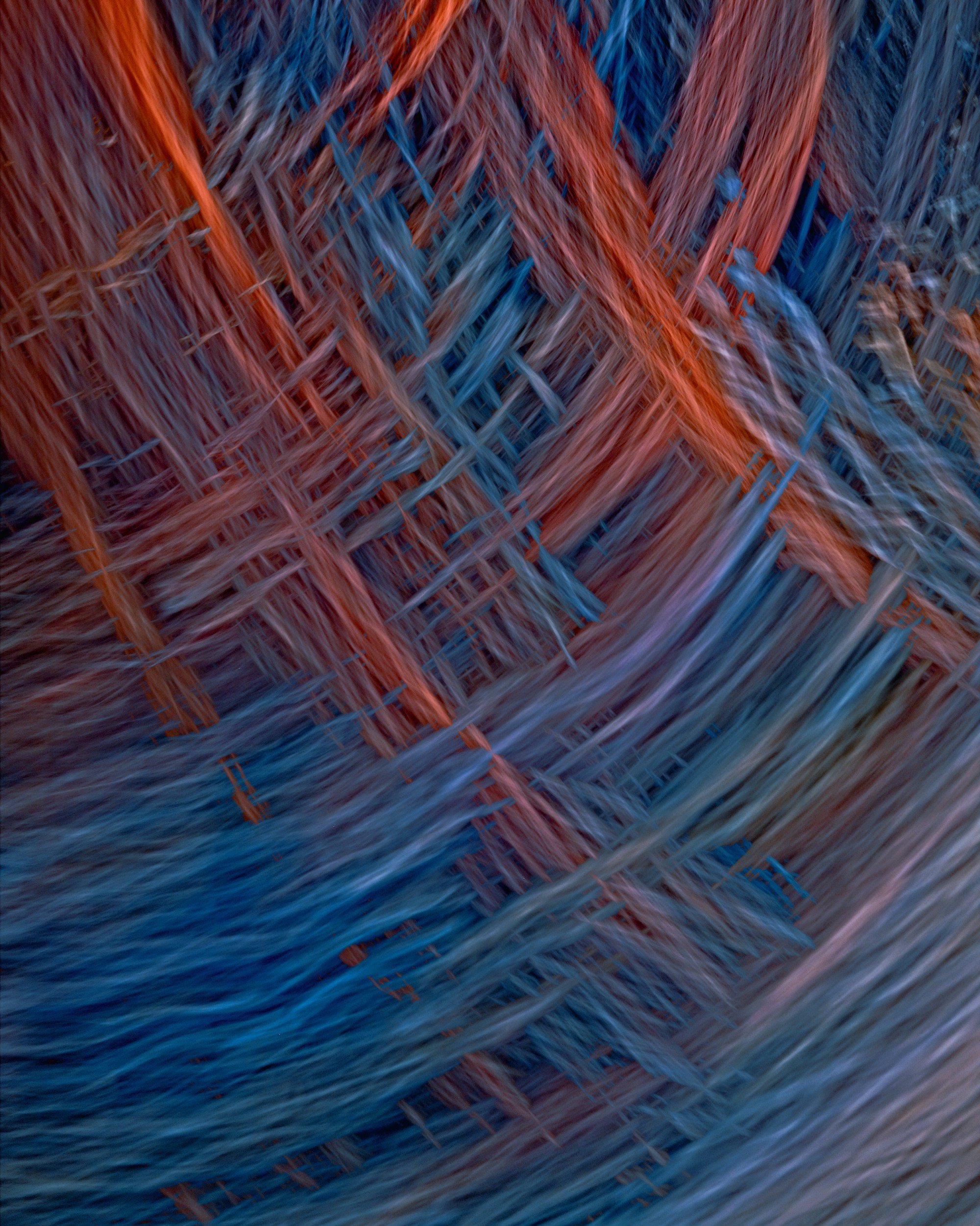 Close-up of woven straw or grass, showing a pattern of overlapping fibers with a gradient of blue and orange hues.