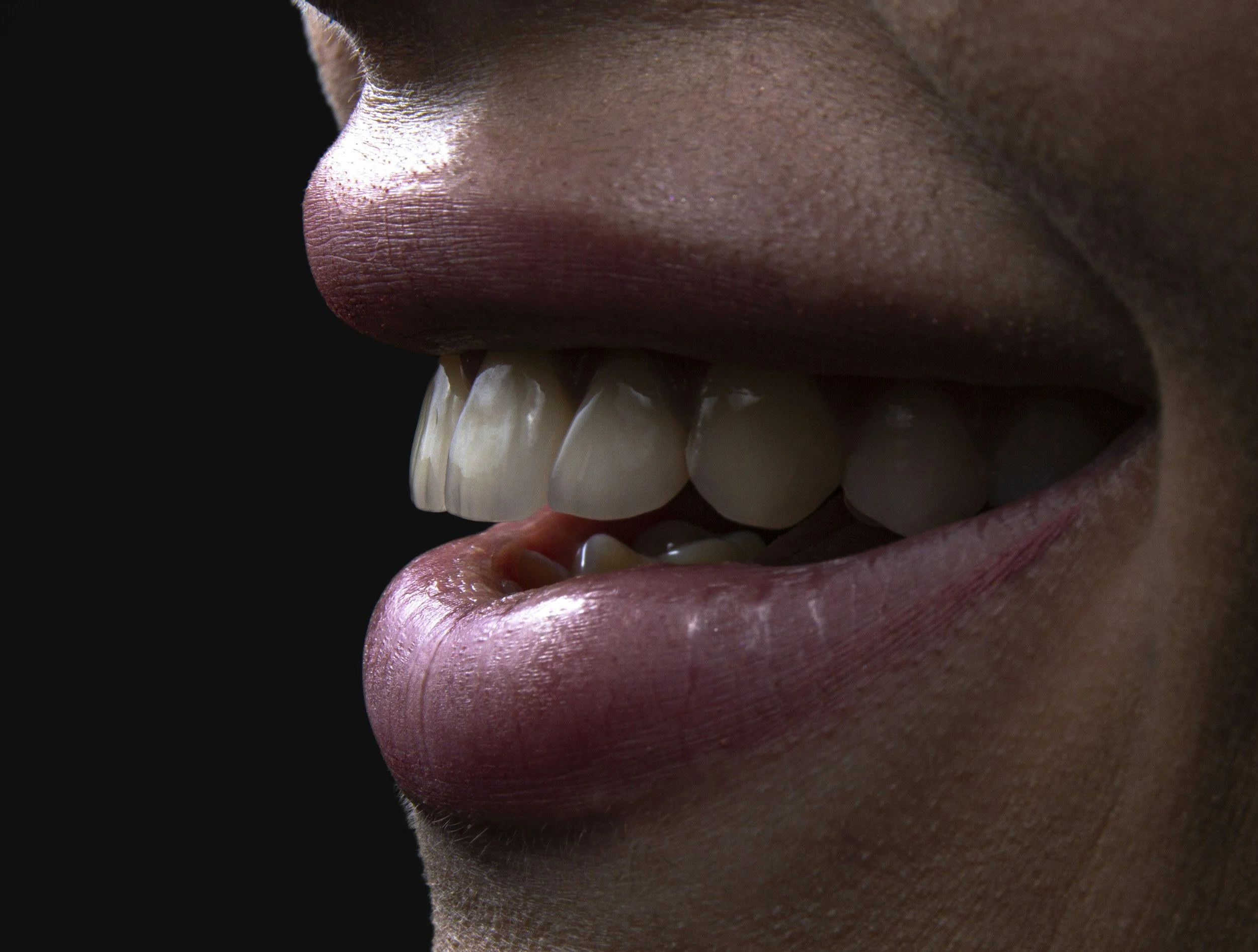 Close-up of a person's mouth smiling, showing upper and lower teeth, with lips slightly parted and skin visible around the lips.