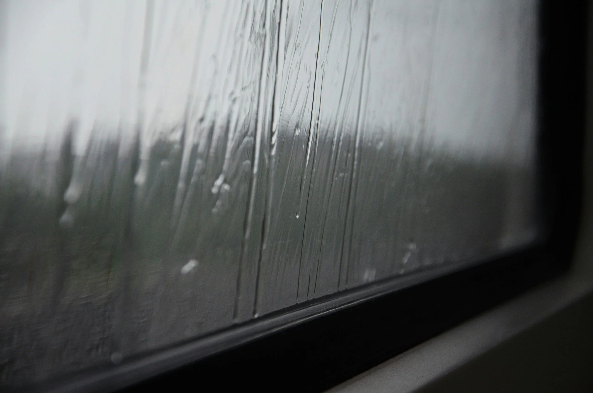 Rain streaks on a windowpane during inclement weather.