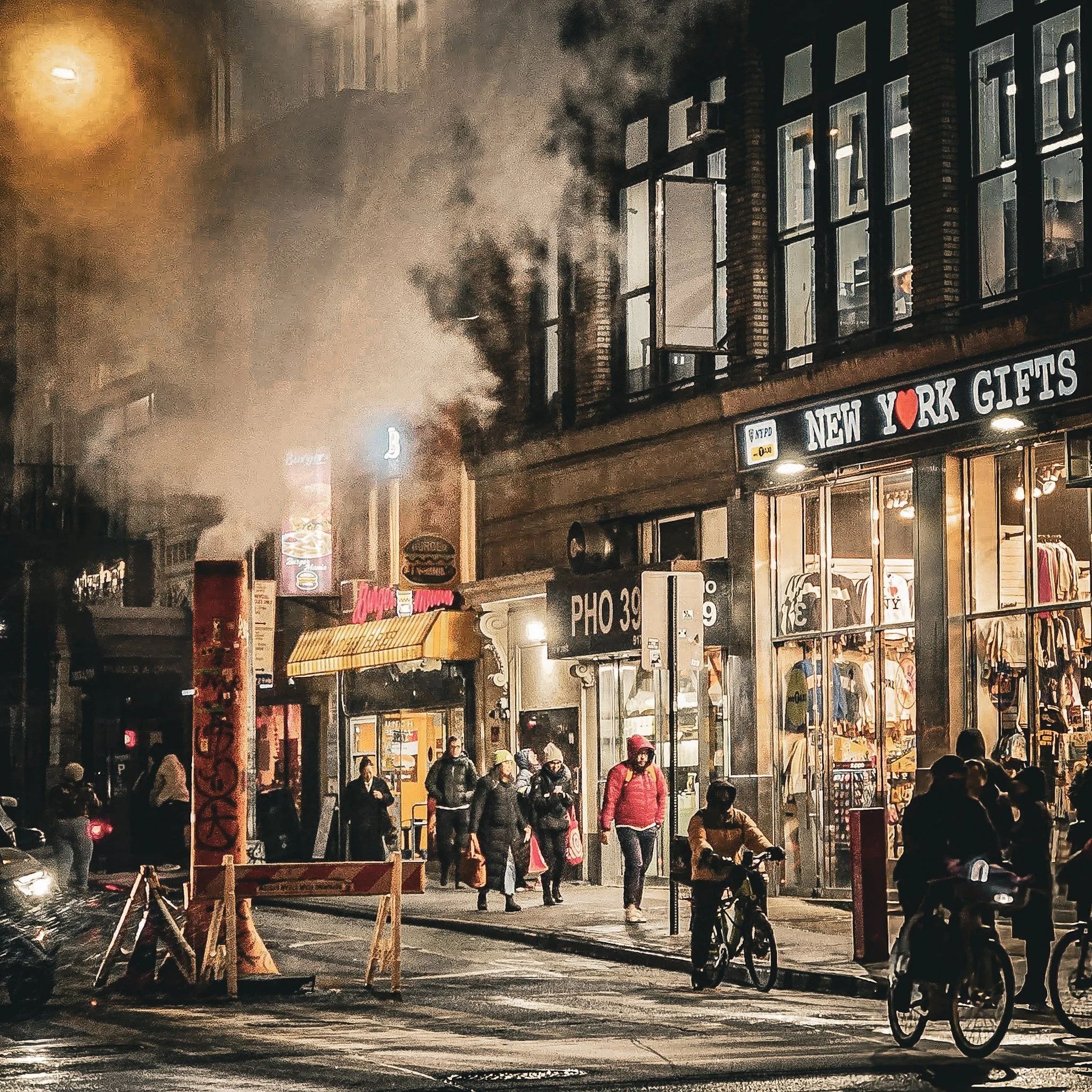 rue de new york la nuit avec colonne de fumee qui sort d une bouche d egout