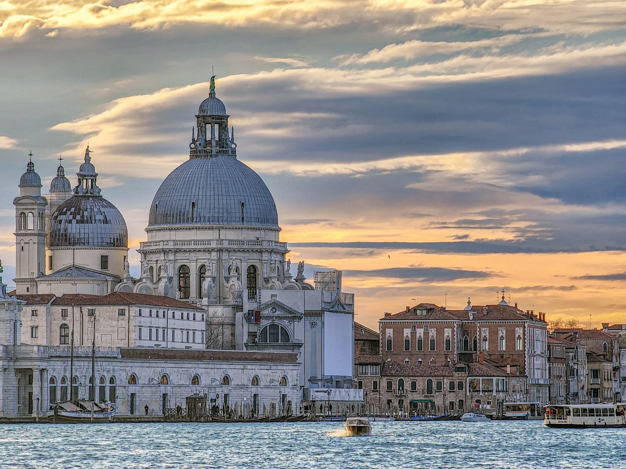 Vue du centre historique de Venise avec la basilique Santa Maria della Salute, au bord du canal, au coucher du soleil.