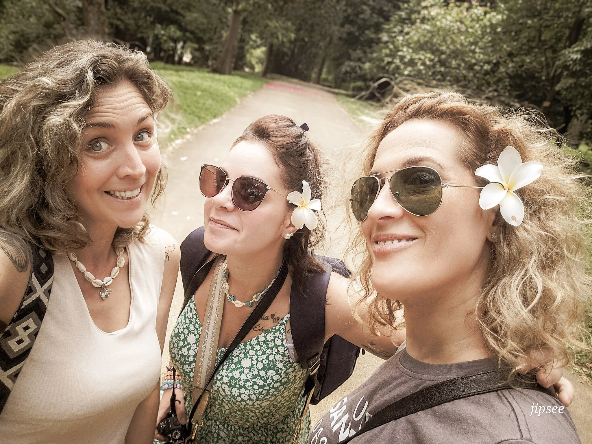 3 filles fesant un selfie au jardin botanique des fleurs dans les cheveux