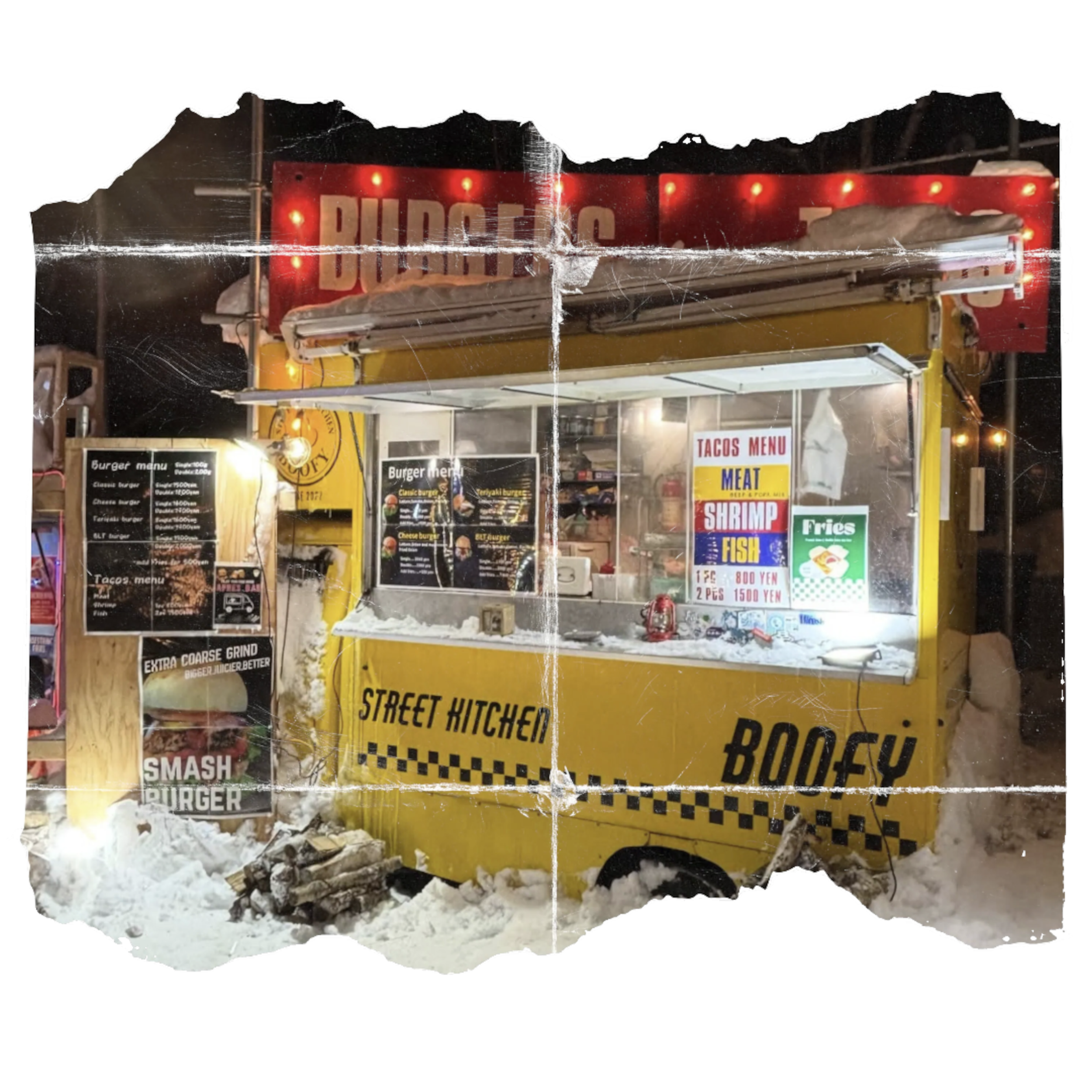 A food stand at night with illuminated signs displaying menu options for tacos, burgers, fried items, and seafood, surrounded by snow on the ground.