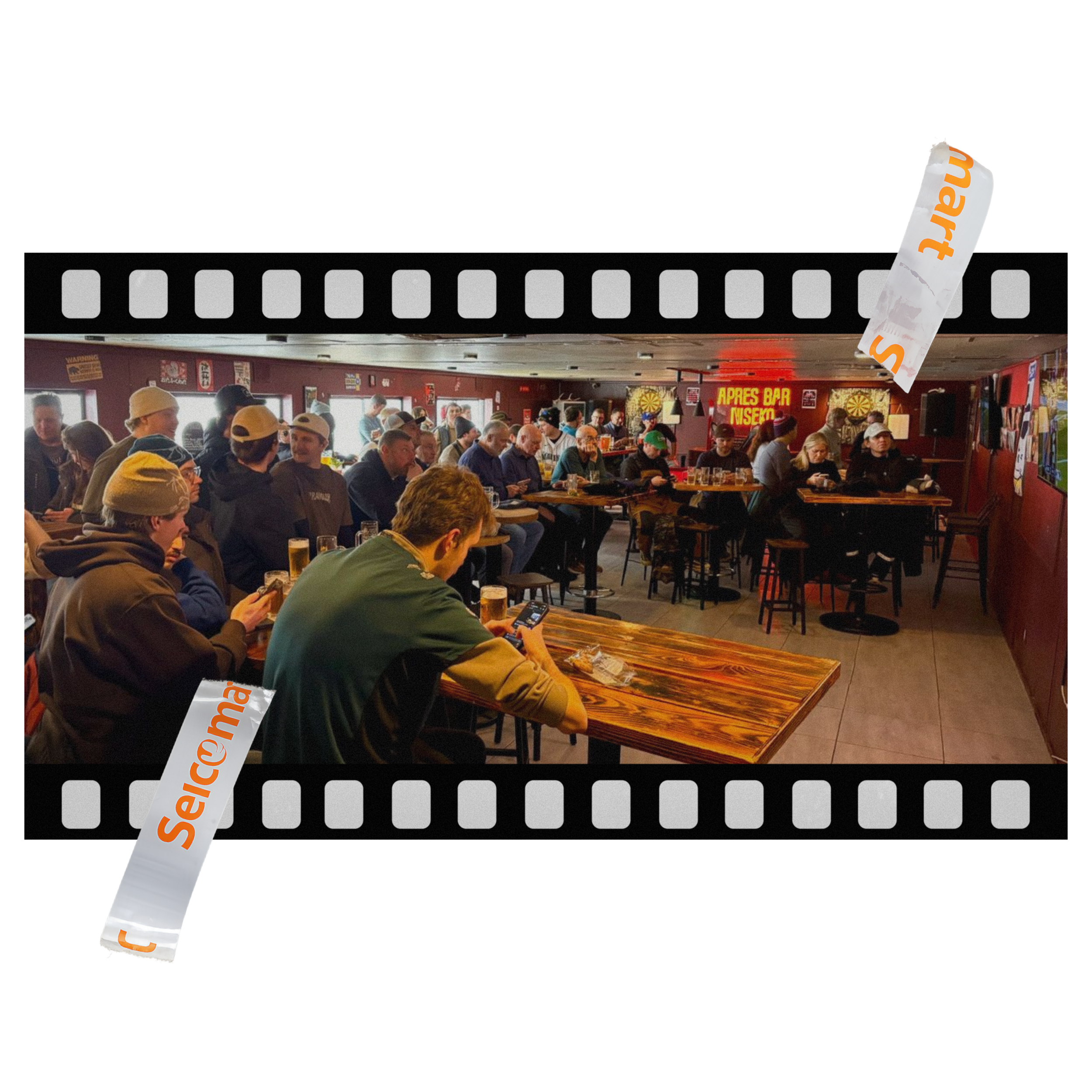 Crowd inside a bar or restaurant with a large sign that says 'Super Bowl' and banners with the 'Smart' logo.