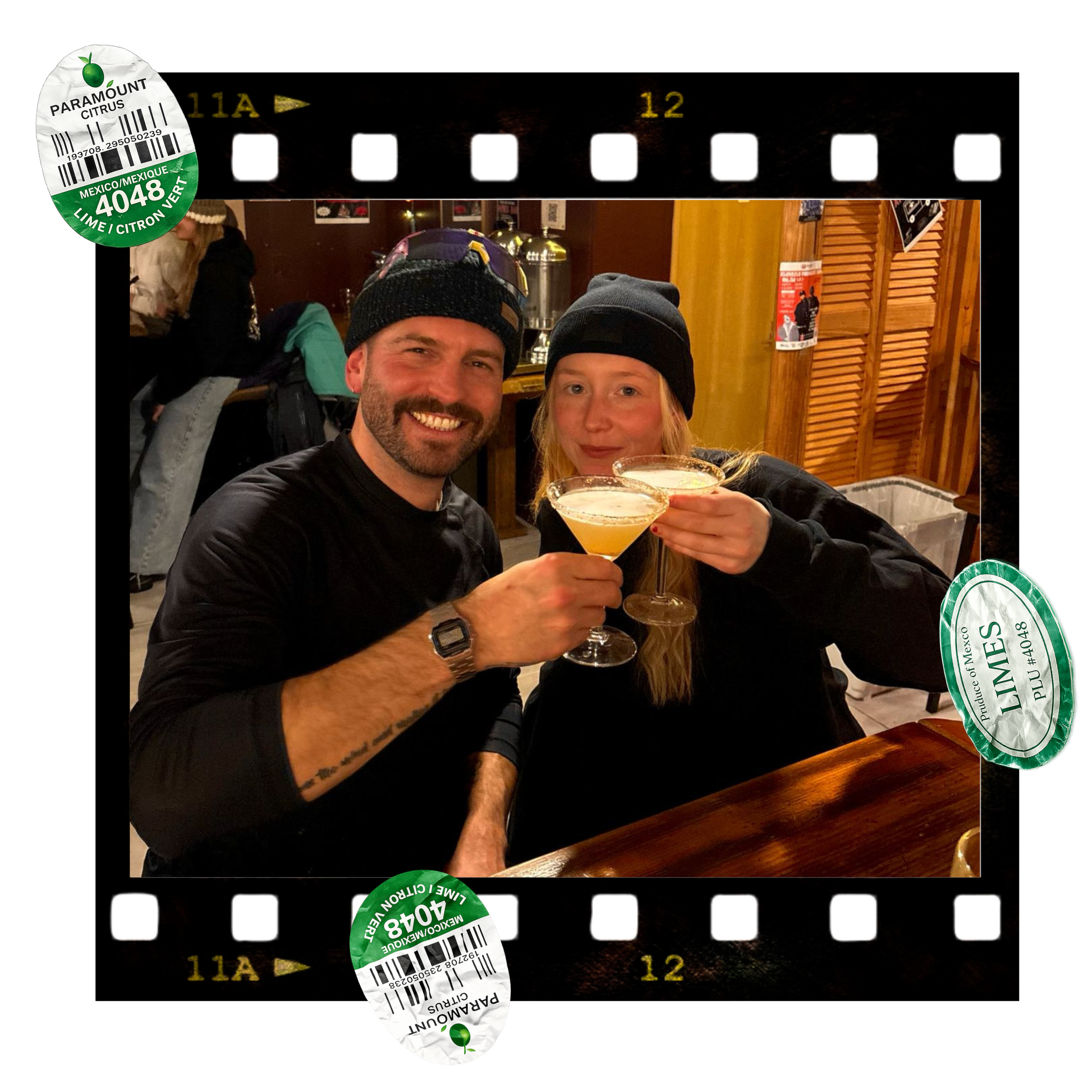 Photo of a man and woman smiling with drinks in a bar or restaurant, with a film strip border and barcodes on the corners.
