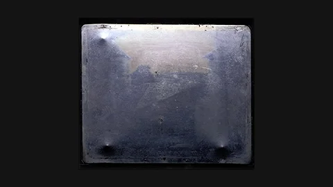 Niépce 1827: blurred rooftop view from upper window, oldest surviving permanent photograph – heliograph on pewter plate