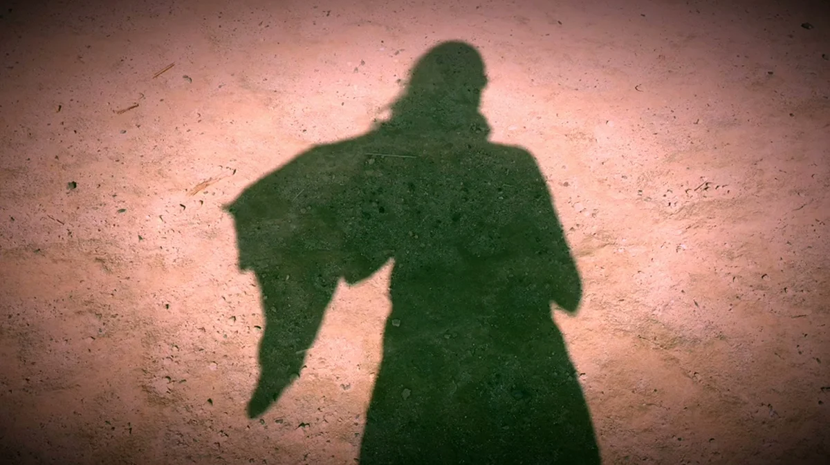 The photographer's own shadow cast on bare earth — a self-portrait of a moment, made to remember.
