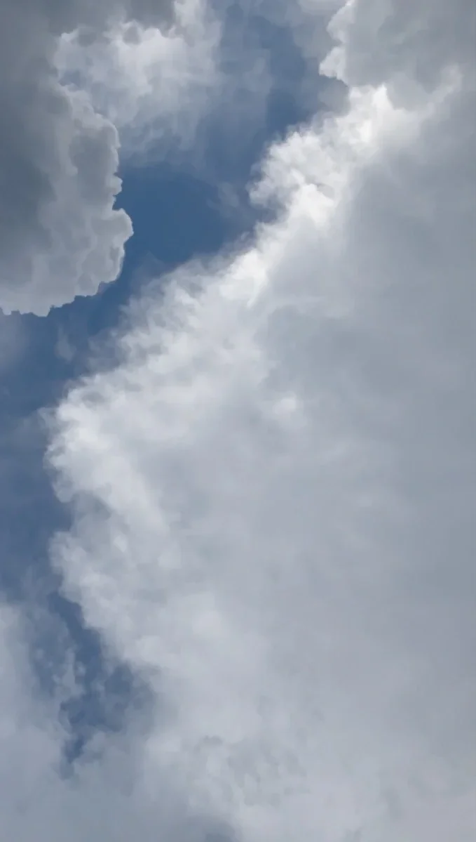 A towering cumulus cloud rises against a clear blue sky — take time to see and think.