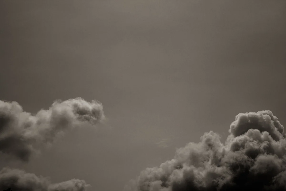 Soft cumulus clouds against a pale grey sky — the kind of subject that rewards slow, patient looking.