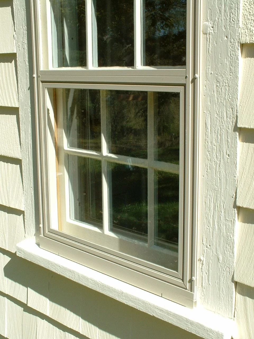 The bottom panel removes to the interior, where it can be replaced with a framed screen.  Both the removable screen and glass panels are held into the storm window frame by clips.