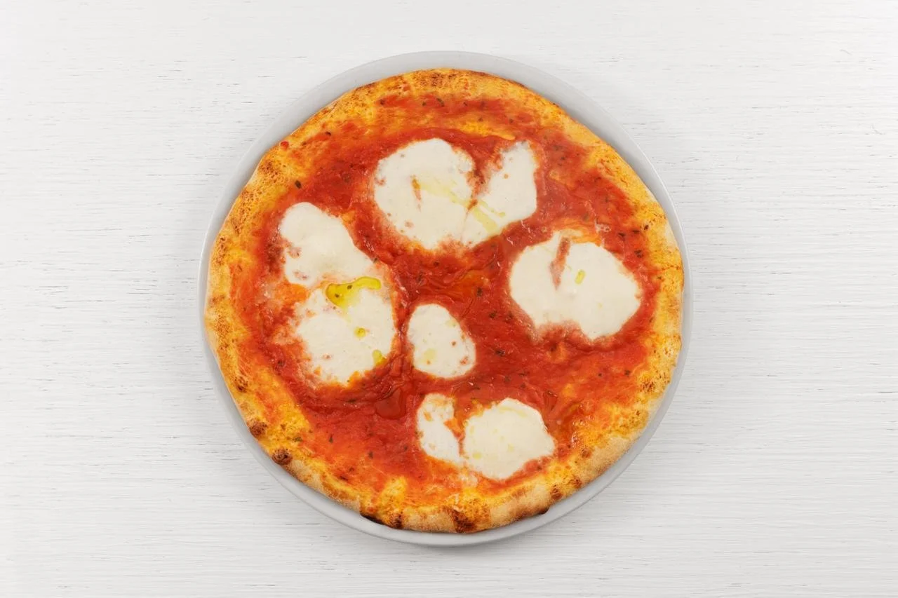 Pizza Margherita con pomodoro, mozzarella e basilico su piatto su sfondo bianco
