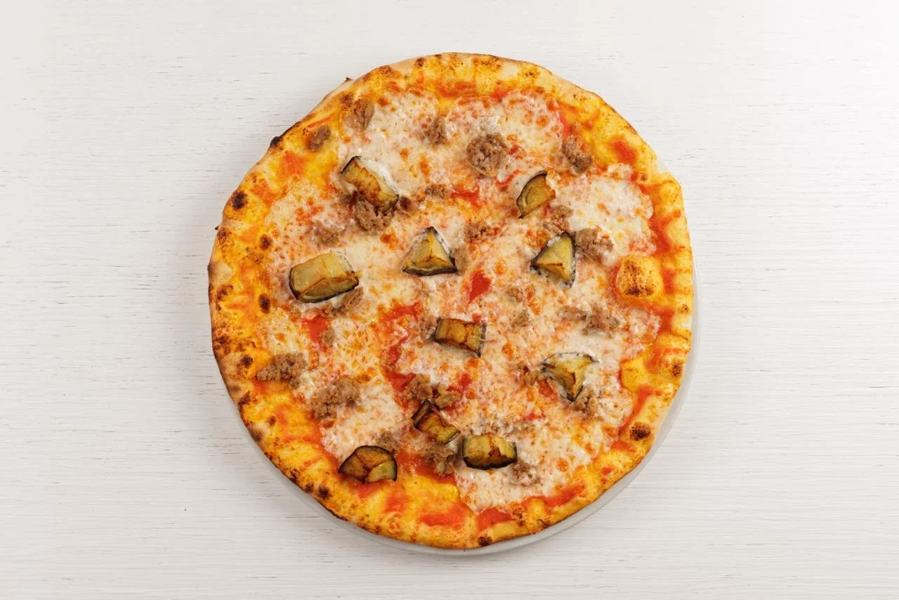 Pizza con formaggio, carne e melanzane su sfondo bianco.