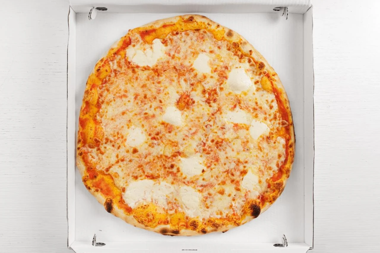 Pizza margherita senza basilico in una scatola di cartone