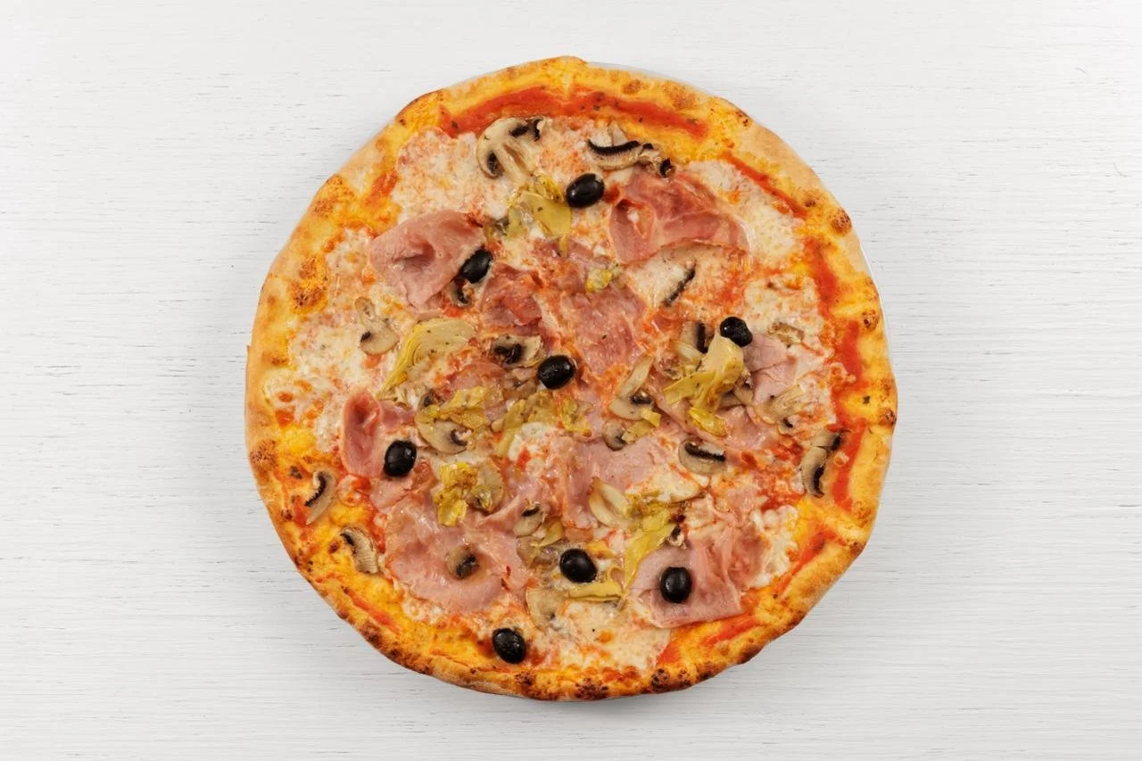 Pizza con prosciutto, funghi, olive nere e carciofi su sfondo bianco