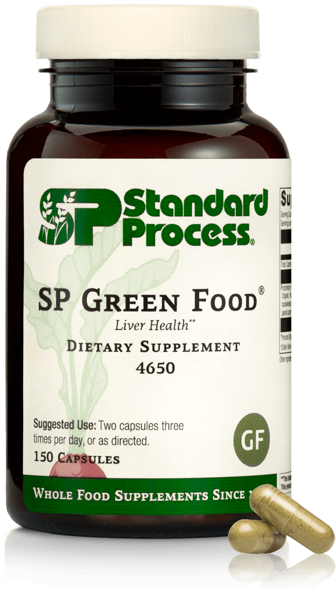 Bottle of Standard Process SP Green Food dietary supplement with three capsules in front.