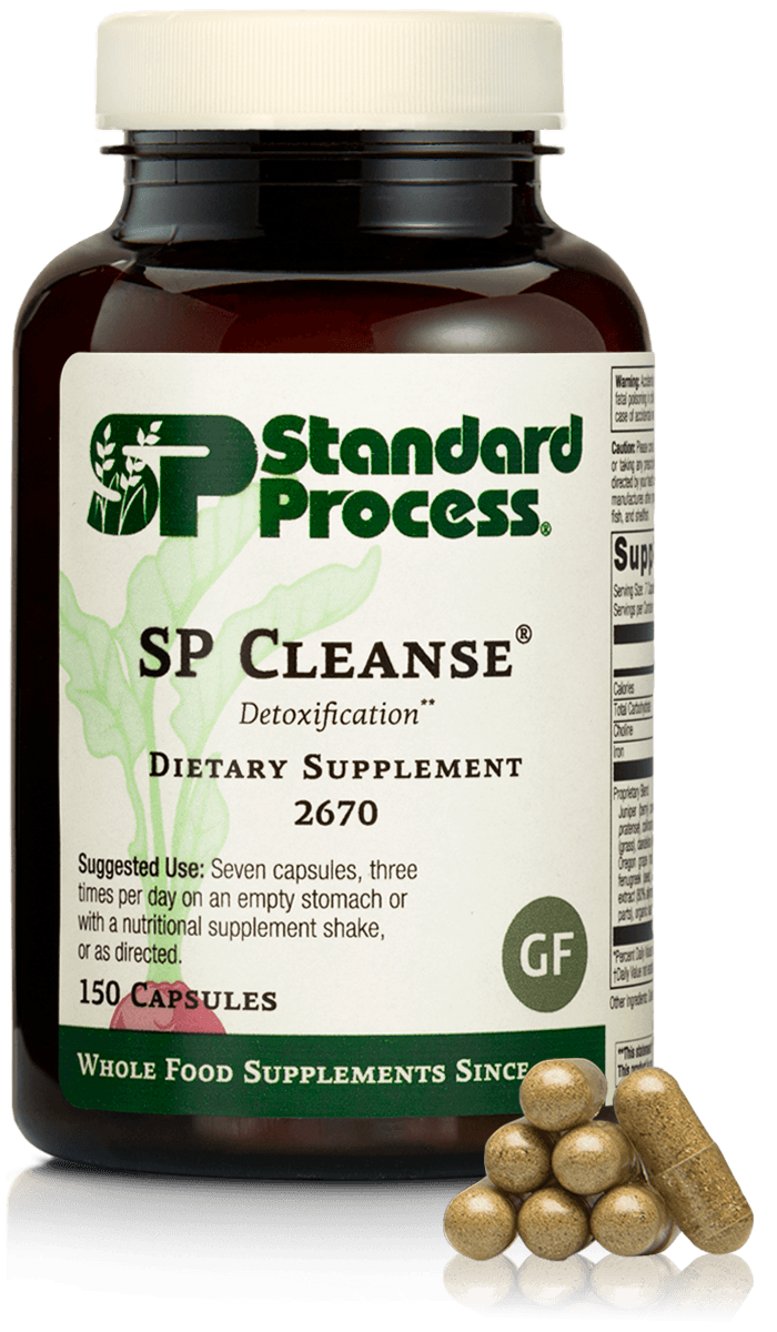 A bottle of Standard Process SP Cleanse dietary supplement capsules with a few capsules placed in front of it.