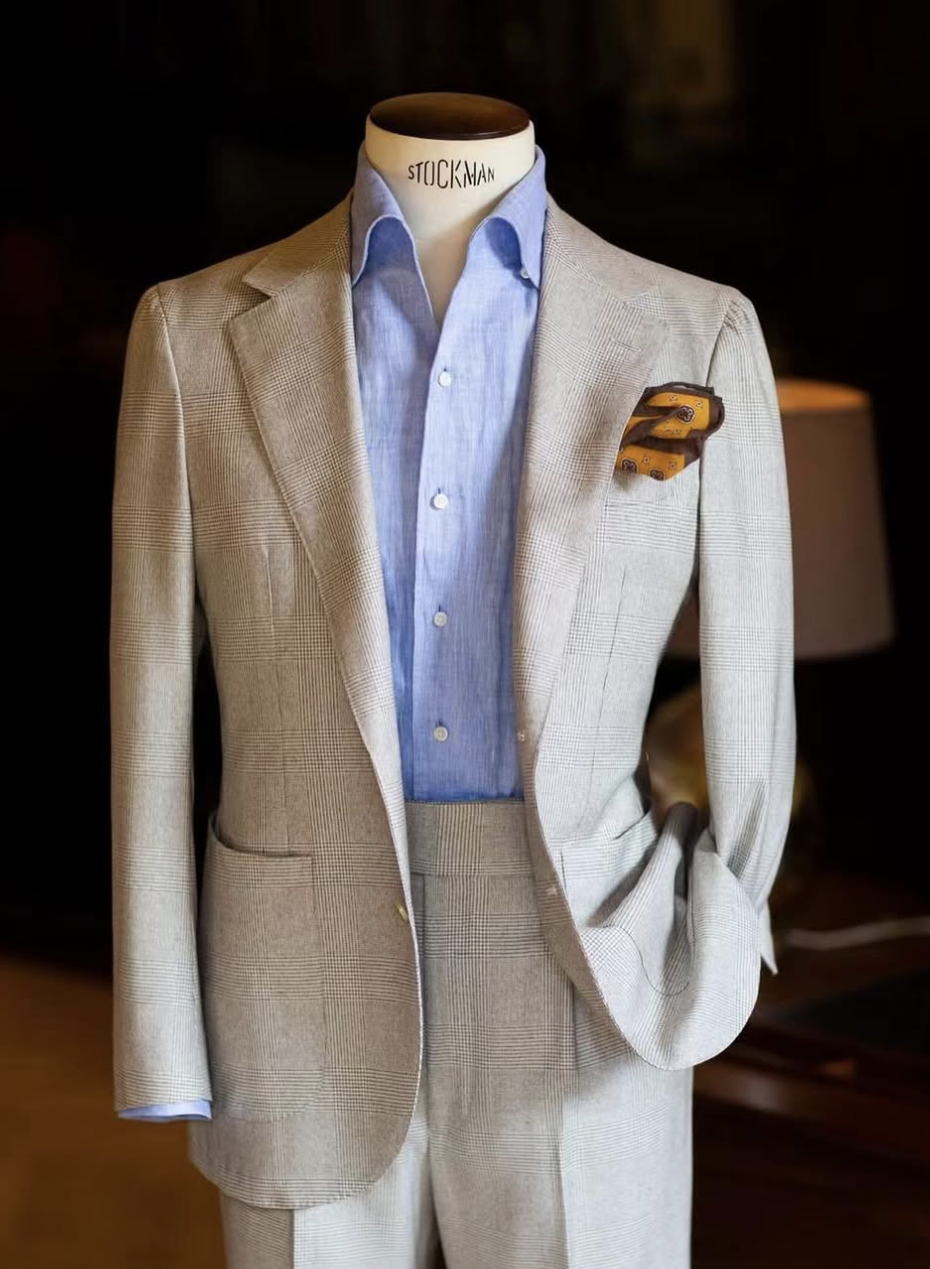 A bespoke suit with light blue shirt.