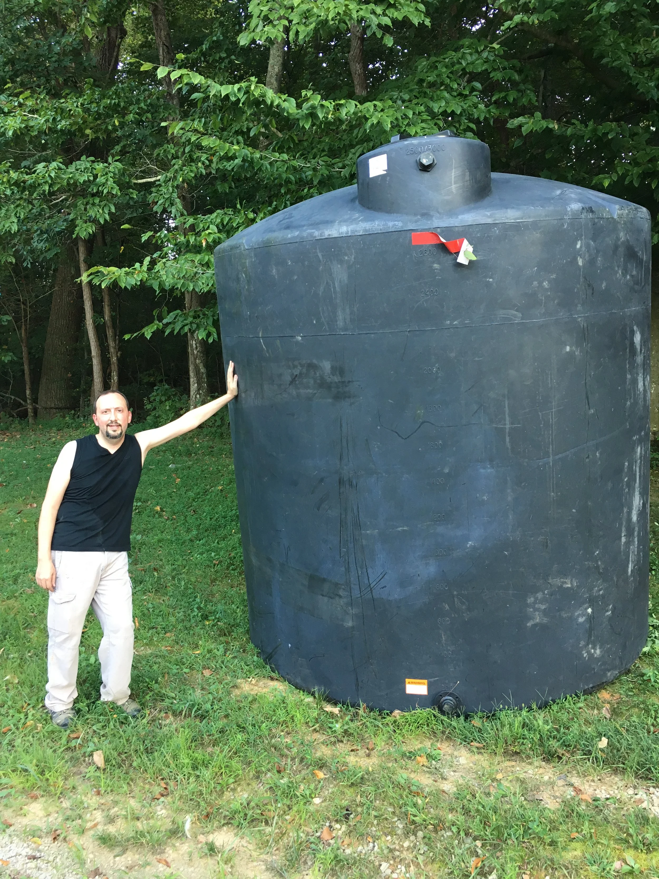 Large plastic cistern with exhausted man holding the side
