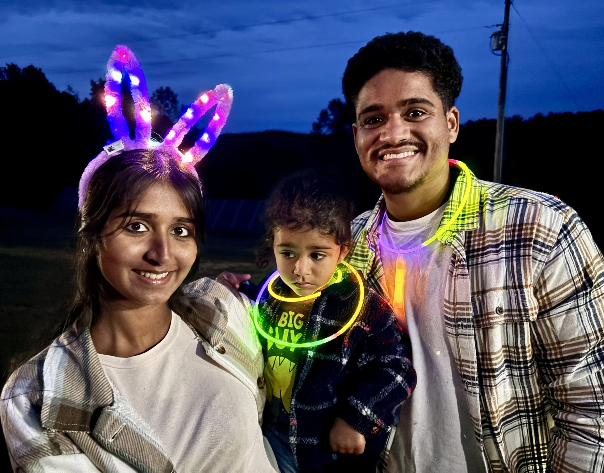  Family holding child with glow in the dark assessoriies at night 