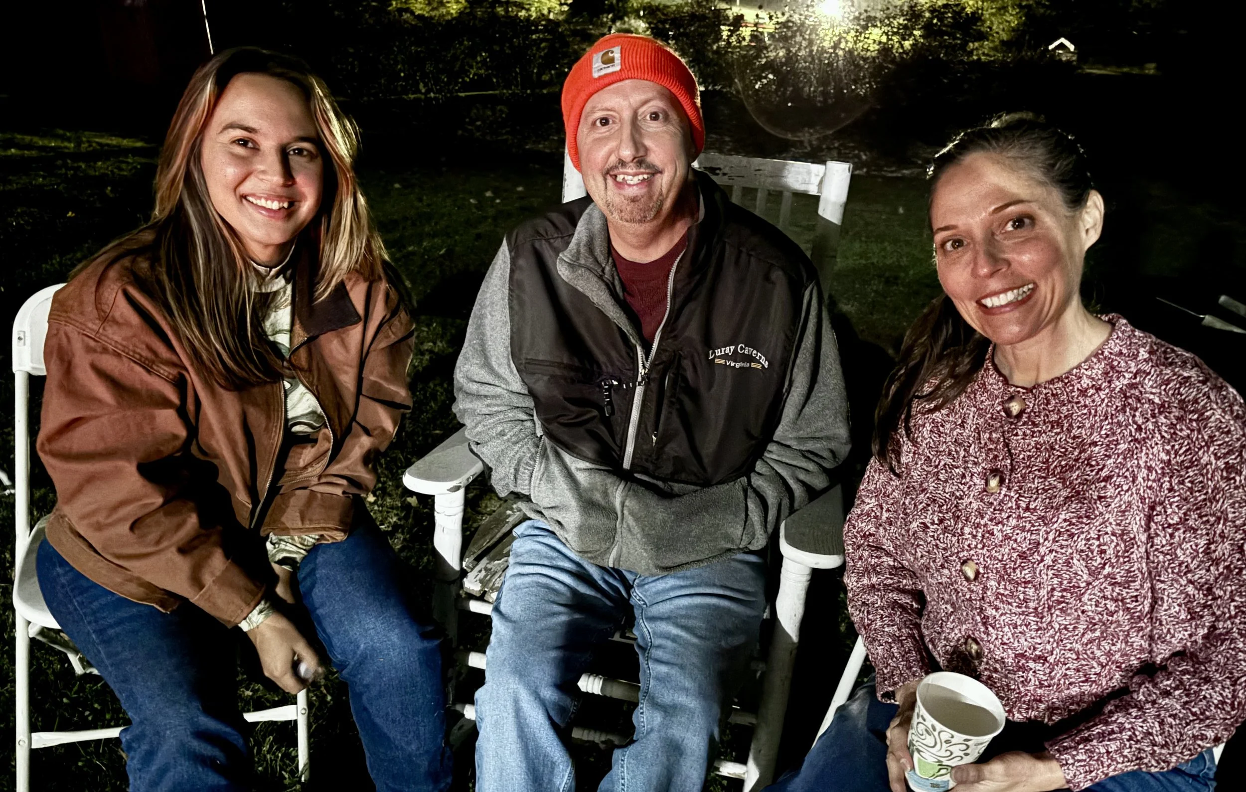  Friends sitting in chairs around a bon fire at night 
