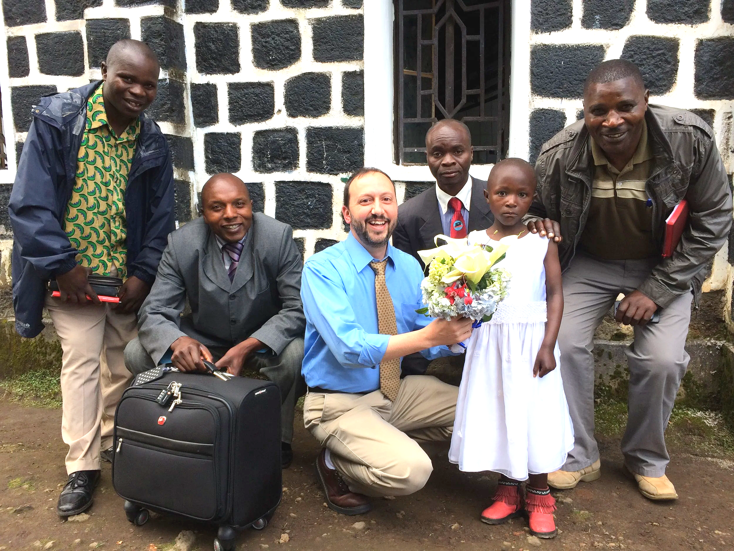 Man accepting a bouquet of flowers as a welcome to arriving in Rwanda