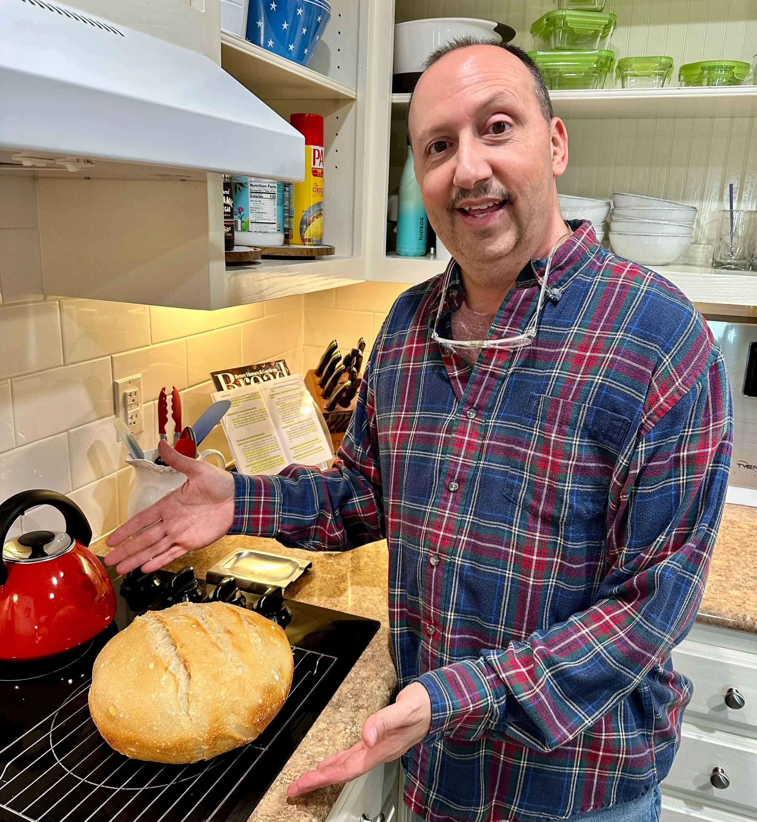 Man displaying sourdough bread loaf baked at home