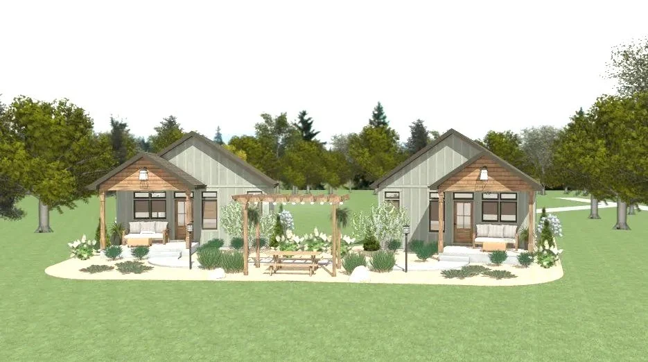 Two small modern cottages with front porches, surrounded by trees and landscaped gardens, under an overcast sky.