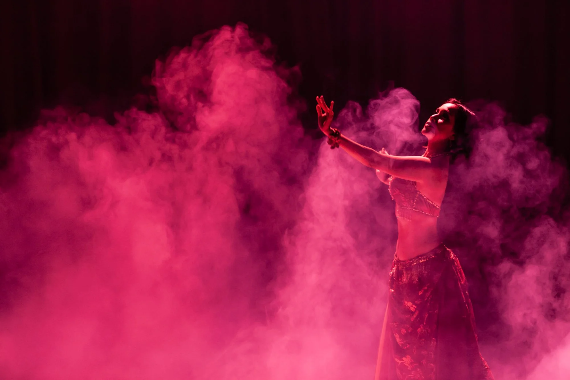 Aruma : Une ambiance mystérieuse et vibrante baignée de fumée magenta.