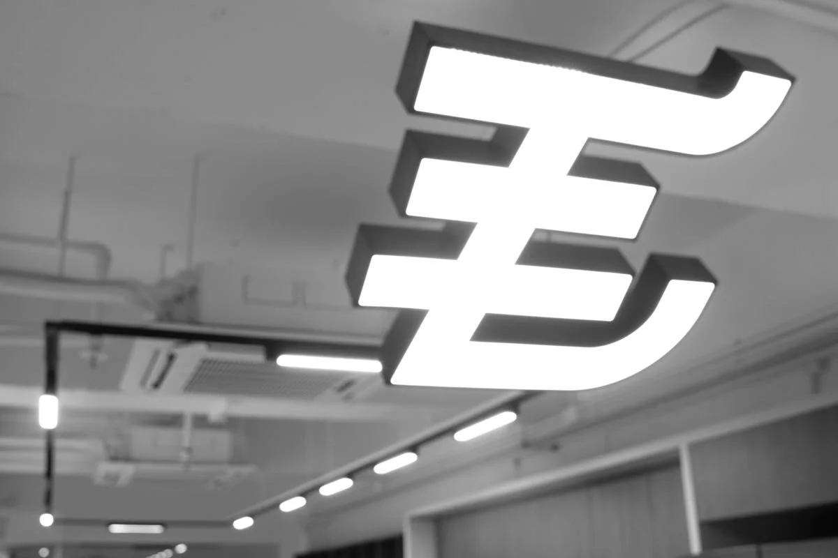 Modern conference room with a prominent illuminated sign of the Euro currency symbol on the ceiling.