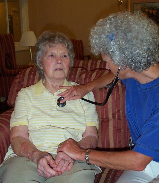 Geriatrics Consulting Services in Greensboro, NC, featuring a medical professional using a stethoscope to examine an elderly woman.