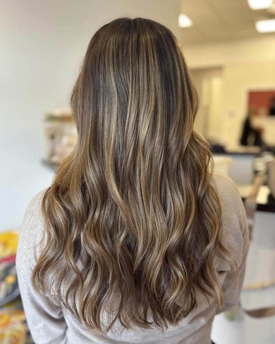 Back of a woman with long, wavy, blonde hair.