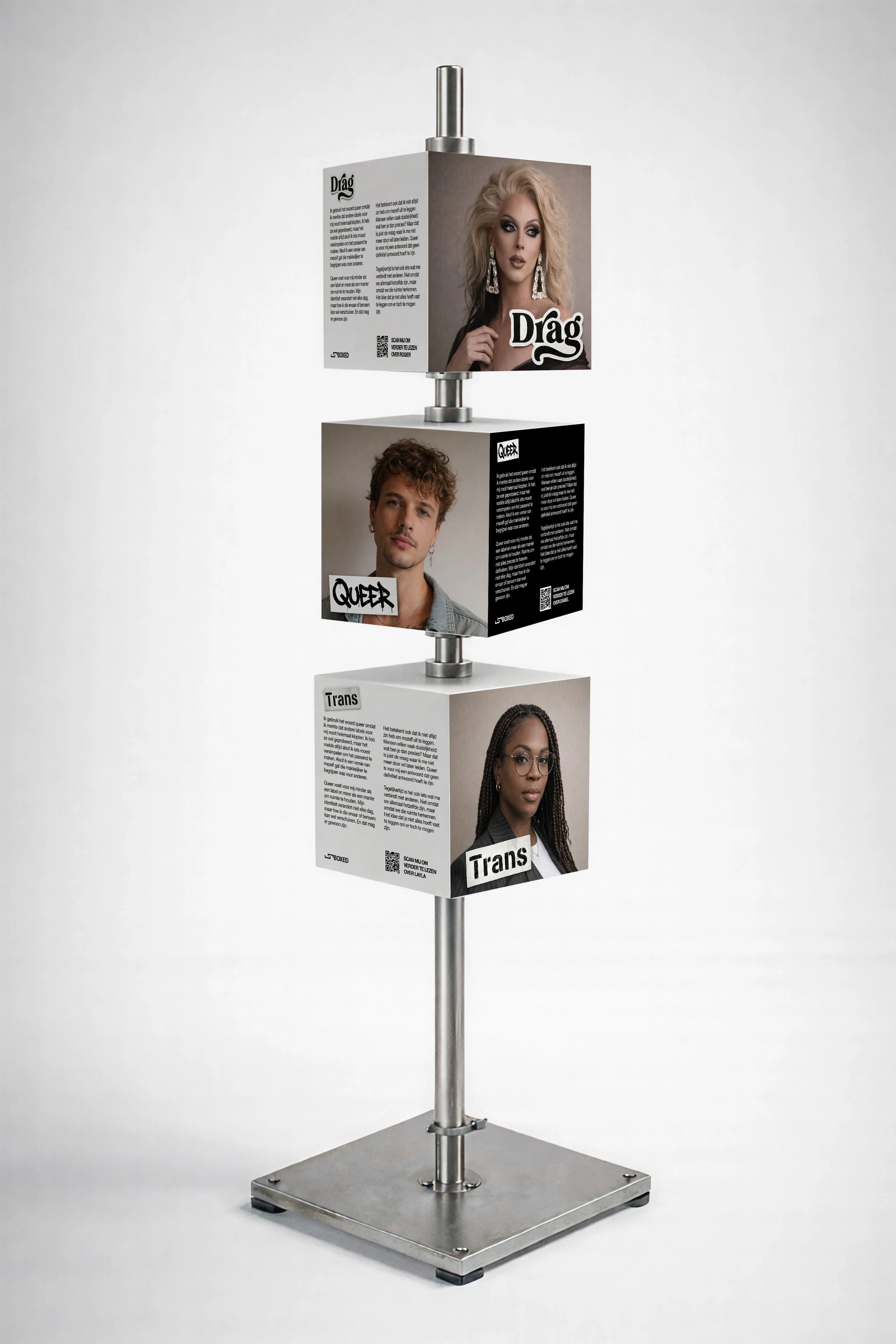 Display stand with three cubes featuring diverse portraits and text, labeled 'Drag,' 'Queer,' and 'Trans,' each cube containing images of people and written information.