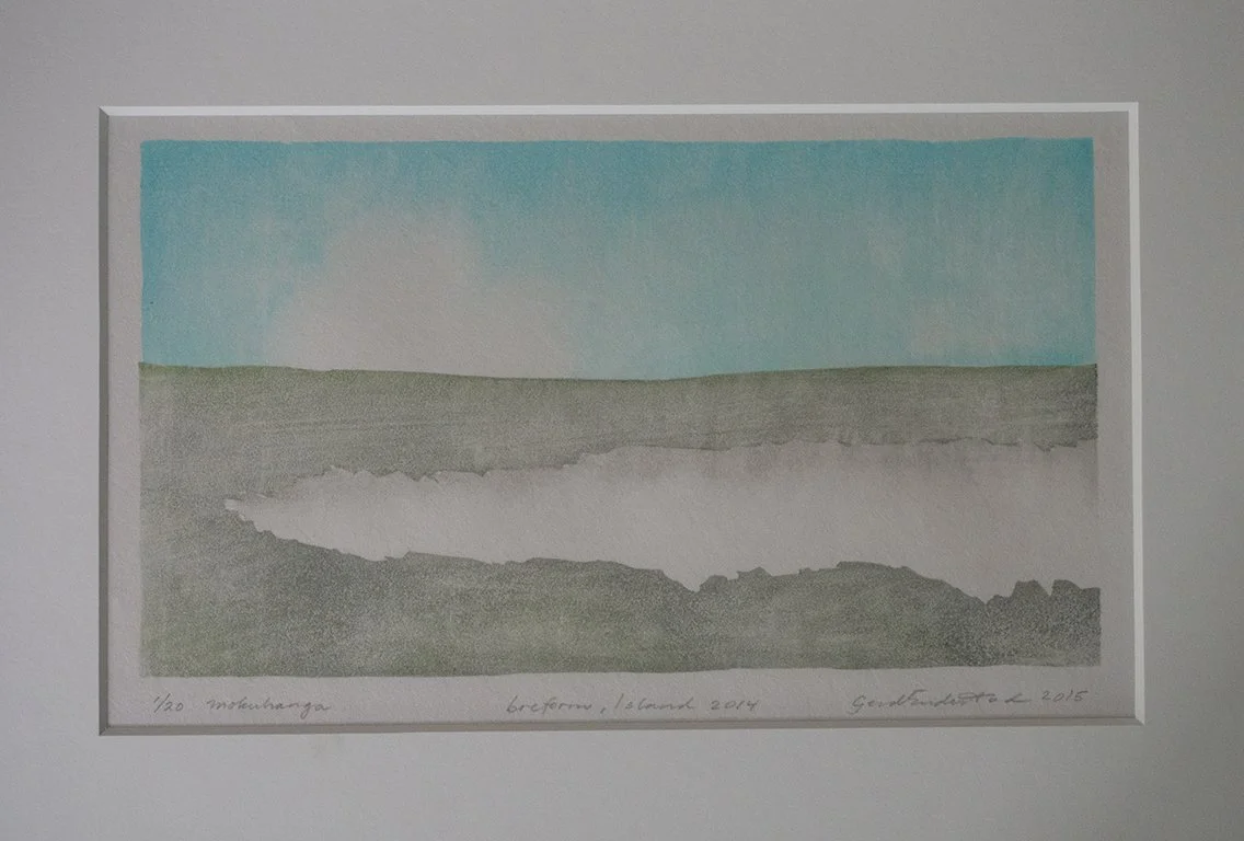 Japanese woodblock print; mokuhanga,  of a flat terrain with a strip of a small glacier and a blue sky, framed and displayed on a wall.Inspired by Iceland landscape.