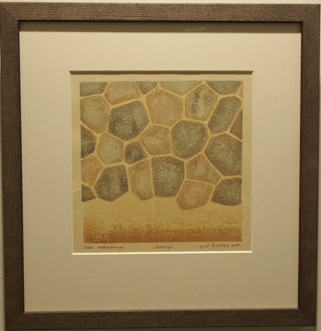 Framed artwork depicting a pattern of hexagonal shapes resembling the top view of a turtle shell or giraffe hide.