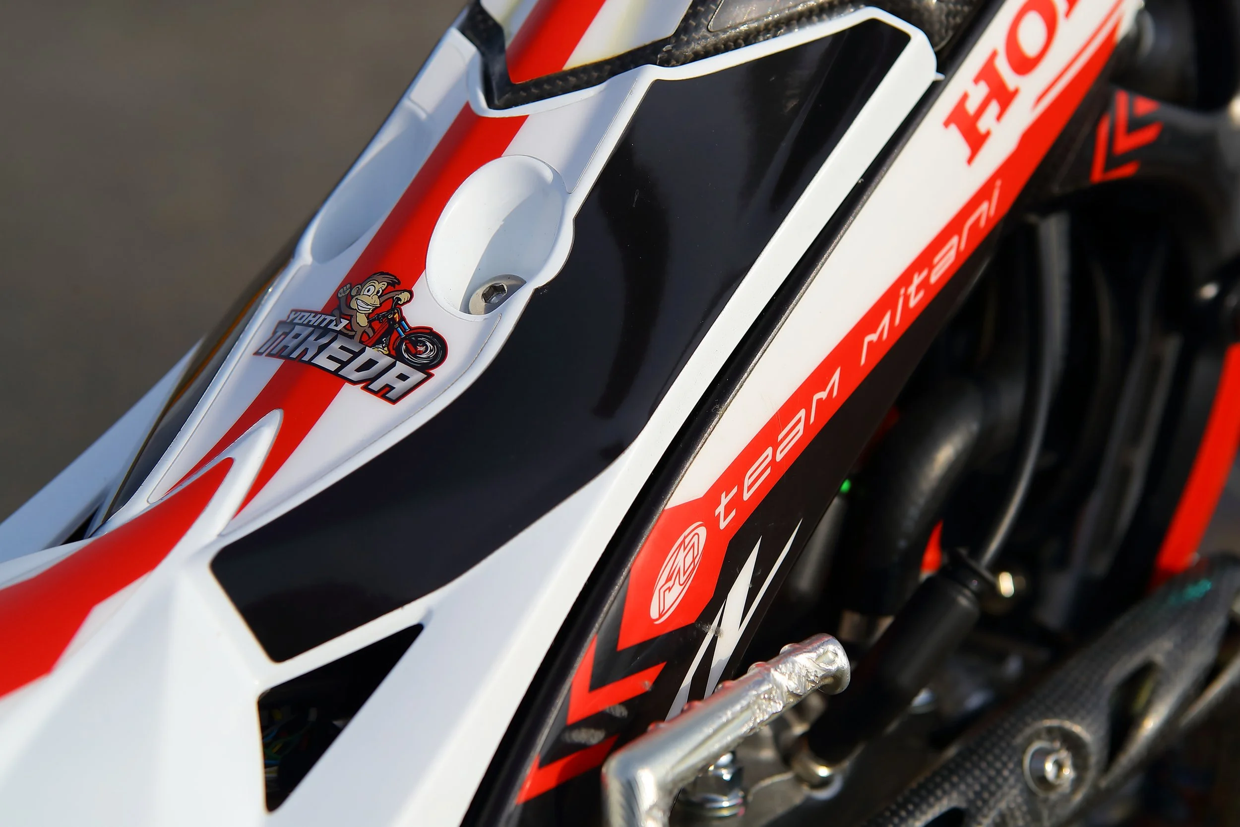 バイクのフロント部分のアップ写真で、Hondaのロゴとウエルカムツアーのステッカーが貼られている