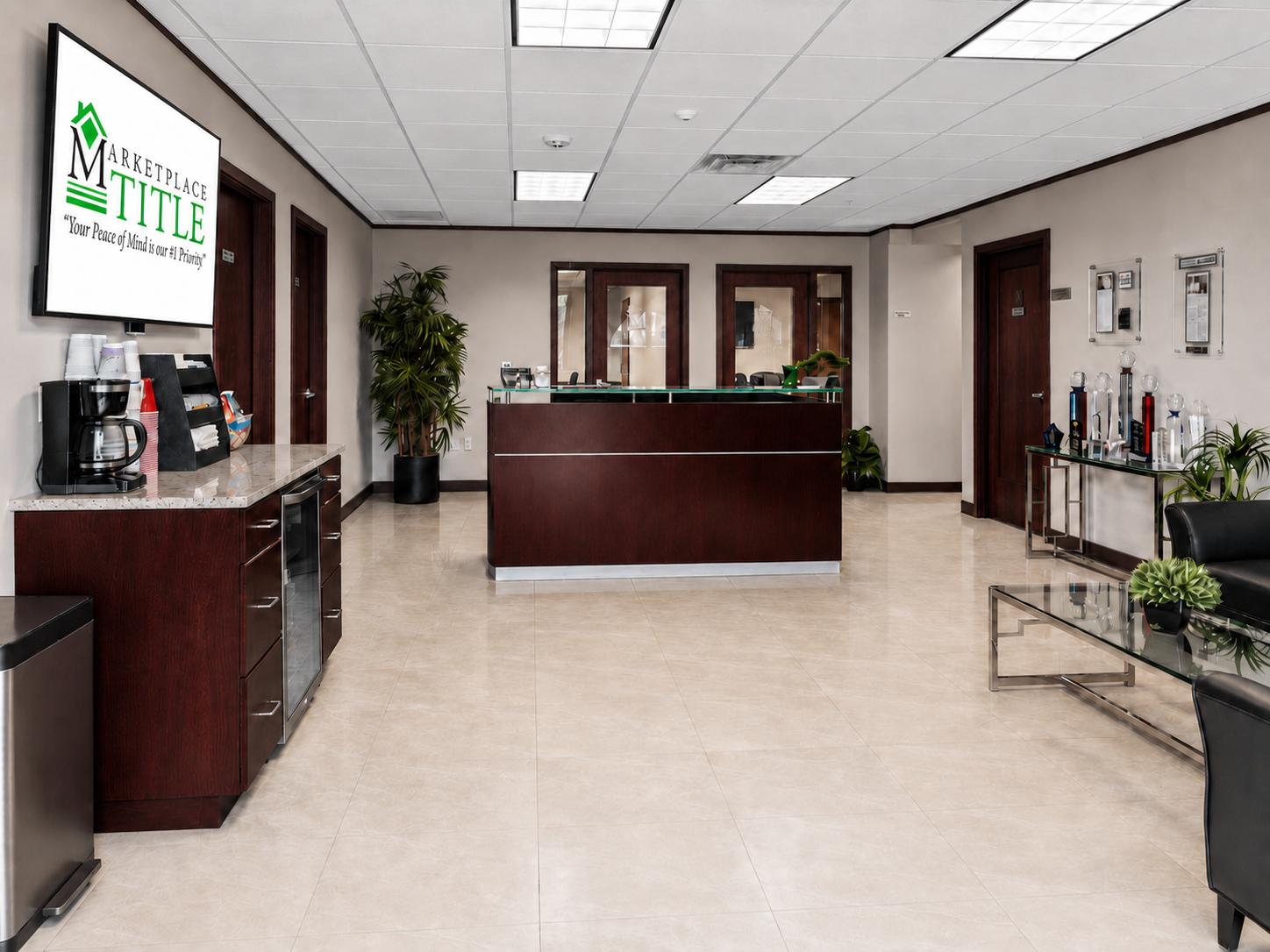Marketplace Title Estero reception area with beverage center, seating area, and awards display in a professional real estate closing office