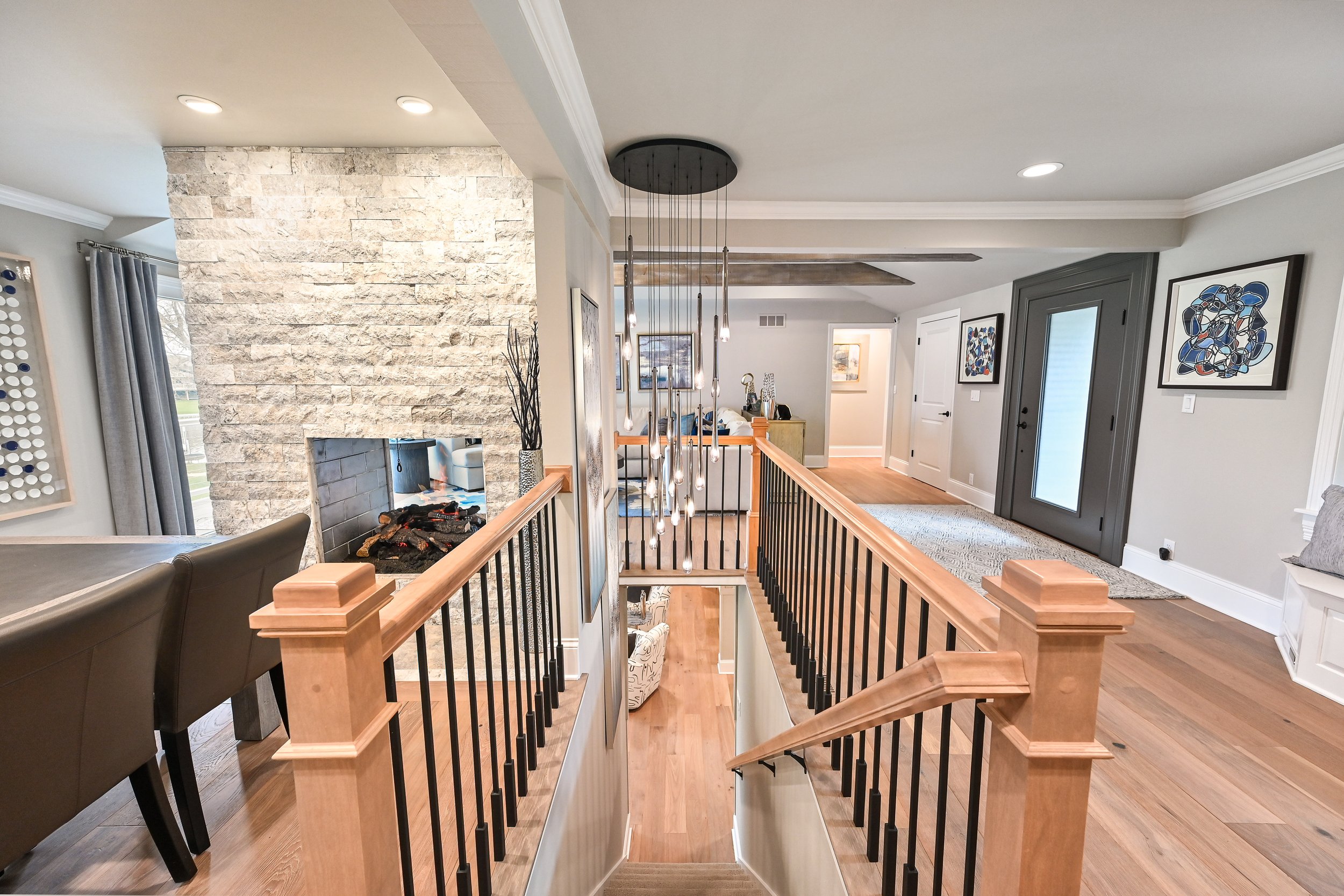 Interior view of a modern home with a staircase, fireplace, and living area.