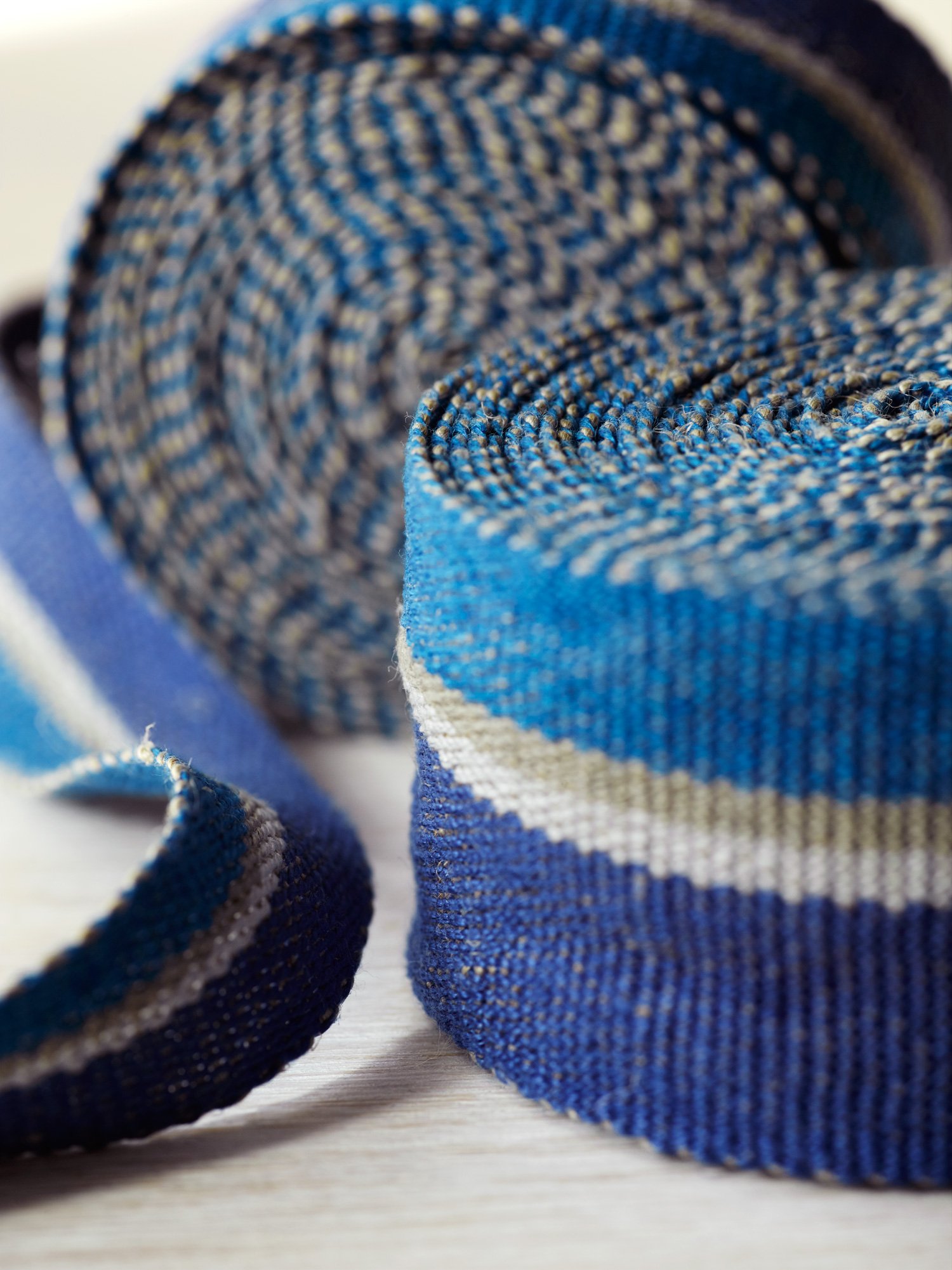 Close up of Ocean handwoven linen tape trim in two bold blues in narrow and medium widths.