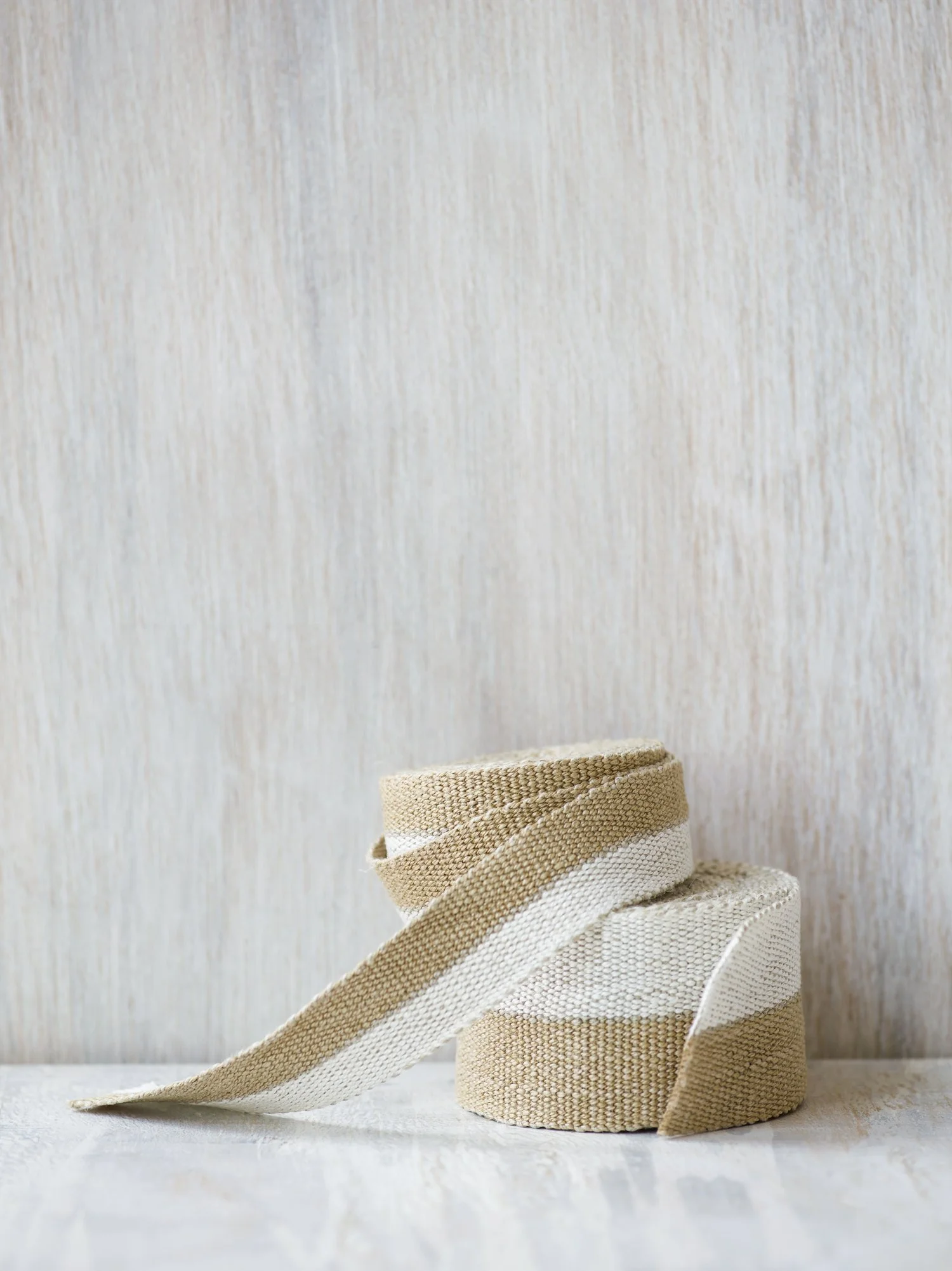 Stack of Modern Neutral III: White and Gold handwoven linen tape trim in half white and half gold in medium and wide widths.