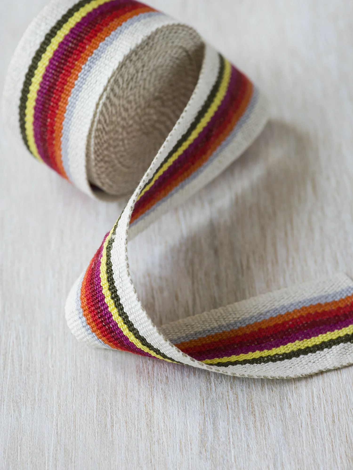 HG 1935 handwoven linen tape trim in vintage rainbow of bright colors on white in medium width.