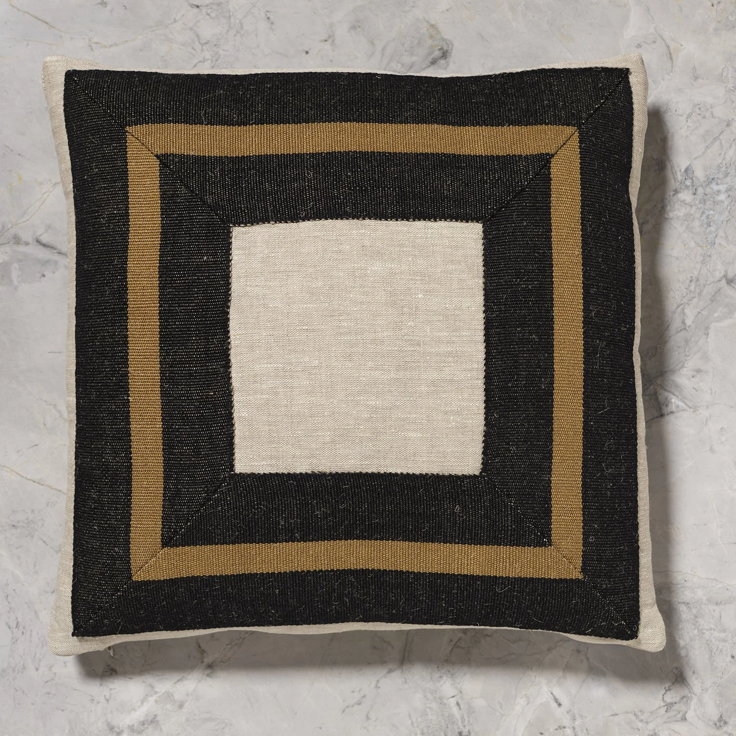 18x18" flax pillow with framed wide detail of MNI Black and Bronze handwoven linen tape trim