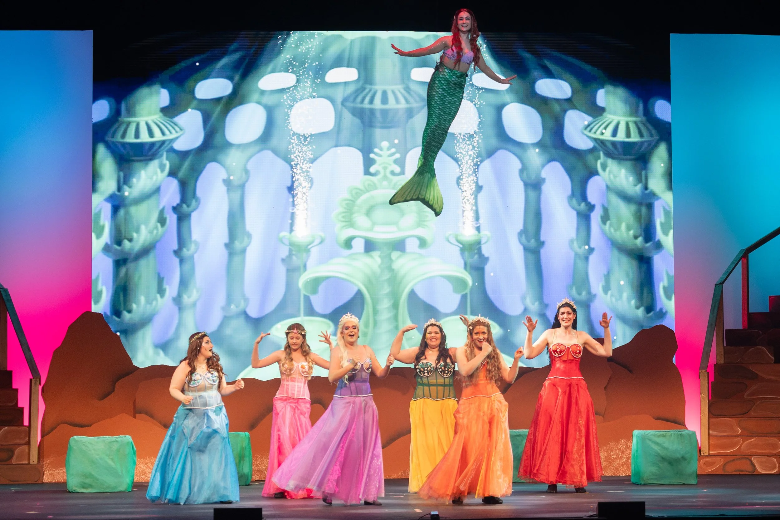 Cat Rojo as Ariel singing and swimming above her mersisters