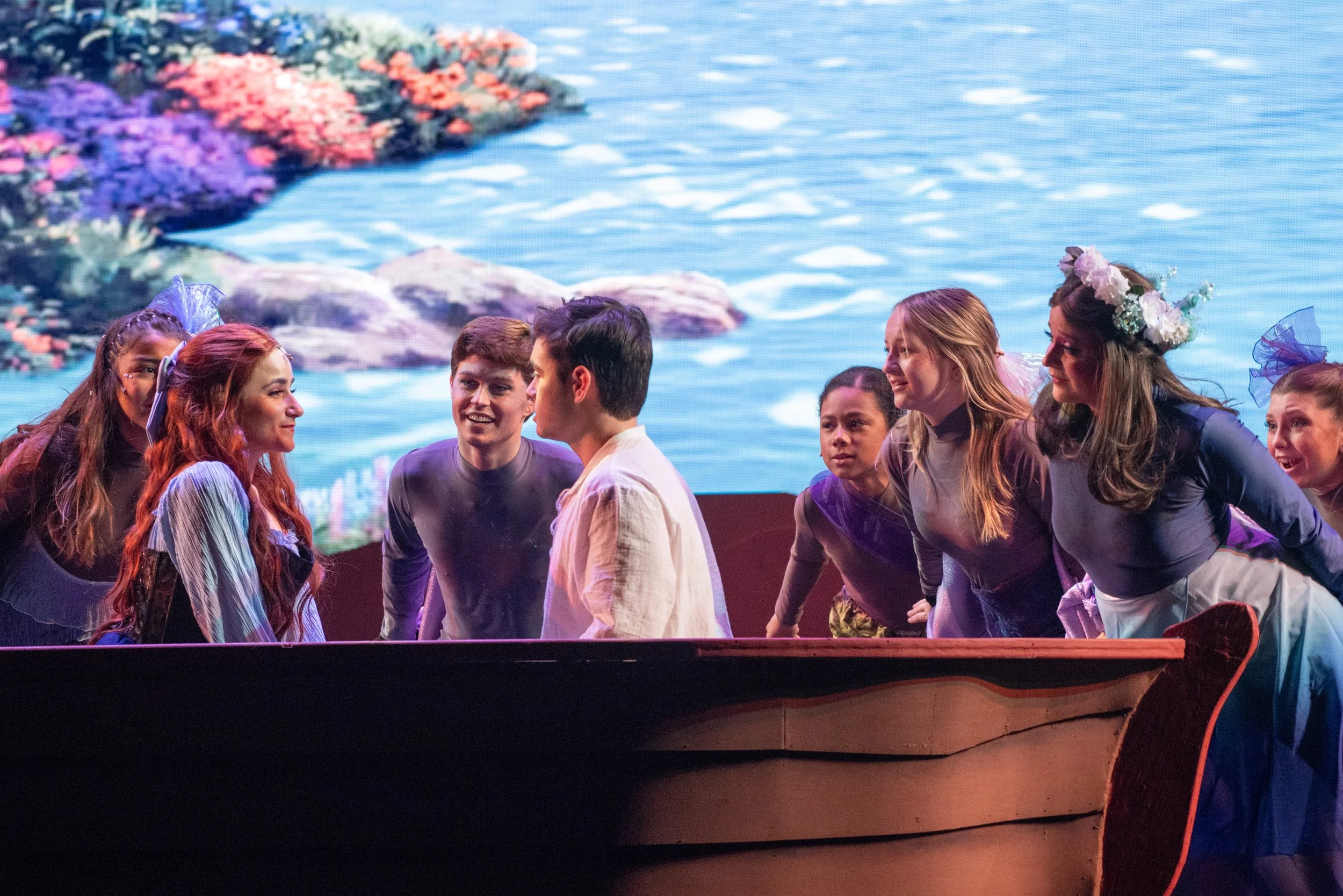 Cat Rojo as Ariel smiling at Eric in a boat during "Kiss the Girl"