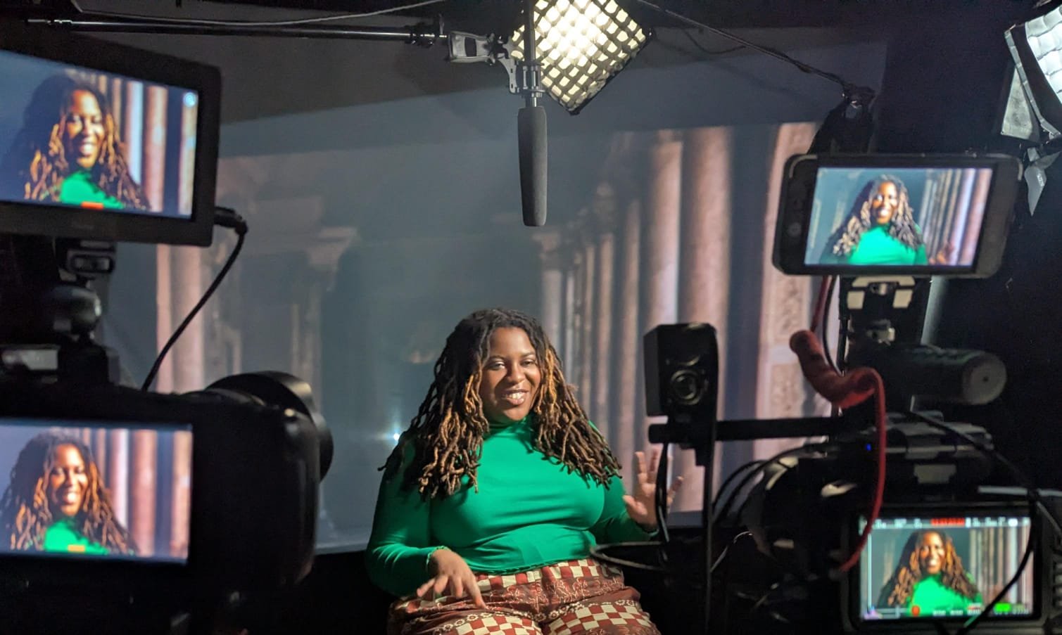 Rachel smiles on set in front of the cameras.
